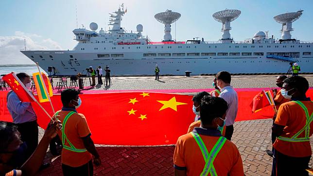 2022年8月16日星期二，斯里蘭卡南部赫班托達（Hambantota），港口工人舉著中國國旗，歡迎搭載了監控設備的中國科學考察船「遠望 5 號」靠港。美聯社