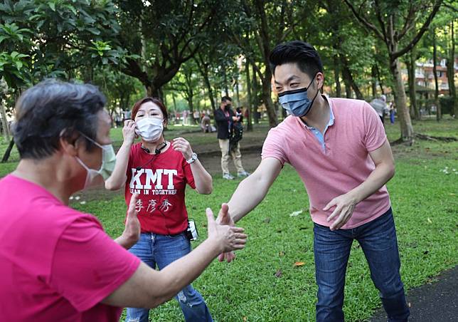 國民黨台北市長參選人蔣萬安向公園內運動的民眾握手爭取支持。（中央社）