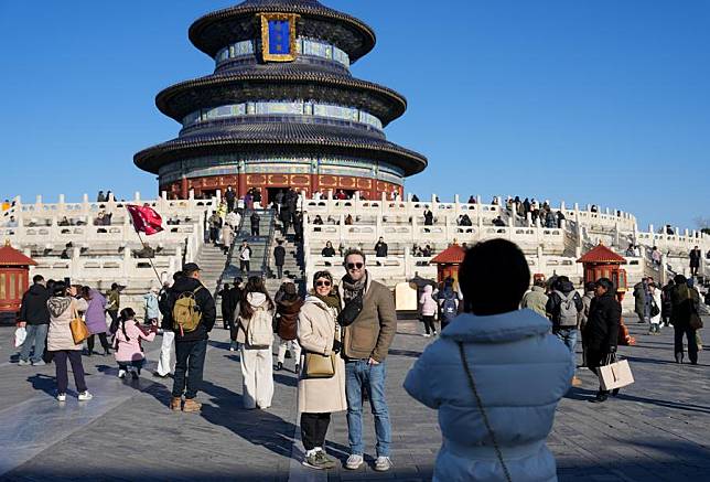 Tourists from Britain pose for a photo at Tiantan (Temple of Heaven) Park in Beijing, capital of China, Dec. 5, 2024. (Xinhua/Ju Huanzong)