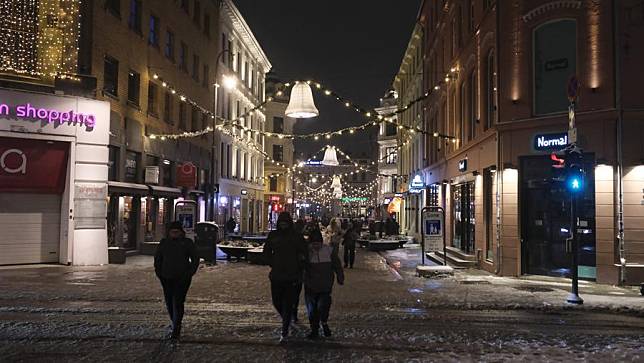 People walk on a street decorated with festive lights in Oslo, Norway, Dec. 31, 2024. (Xinhua/Zhang Yuliang)