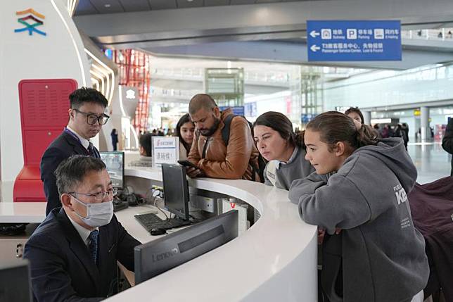 Staff members provide consultation services to passengers from Spain at a service center in Beijing Capital International Airport in Beijing, Jan. 8, 2025. (Xinhua/Ju Huanzong)