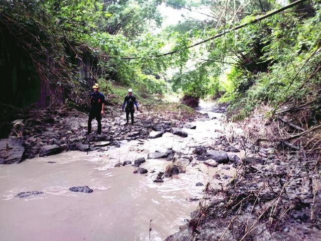 高雄警義消沿著田寮牛稠埔溪河道，搜尋疑遭暴漲溪水沖走的陳姓農婦（記者鐘敏綺／翻攝）