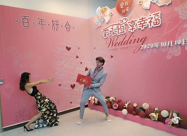 美籍先生與吳小姐在國慶日登記結婚，成為台灣女婿，兩人KUSO在結婚背板合影紀念。(記者蔡淑媛翻攝)