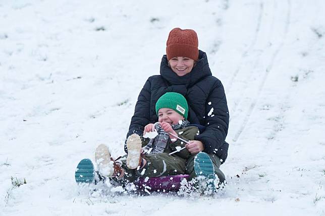 People enjoy sledding in the snow in Manchester, Britain, on Jan. 5, 2025. (Photo by Jon Super/Xinhua)