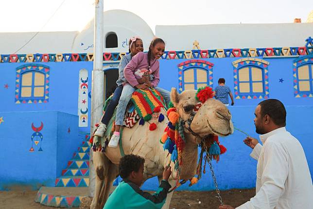 Children ride a camel at the Nubian village of Gharb Sohail in Aswan, Egypt, Nov. 24, 2024. (Xinhua/Sui Xiankai)