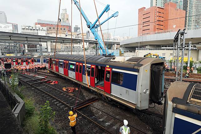 Rail engineers try to lift a carriage back on track near Hung Hom as part of the effort to get services up and running again for Wednesday morning. Photo: Sam Tsang