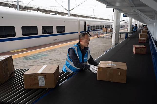 The file photo shows workers unload e-commerce parcels from a bullet train at Shuangliu West Railway Station in Chengdu, southwest China's Sichuan Province. (Xinhua/Jiang Hongjing)