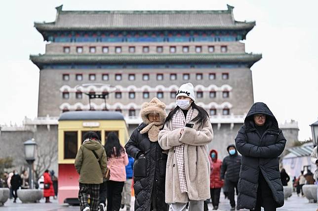 People walk on the Qianmen Street in the strong wind in Beijing, capital of China, Feb. 6, 2025. (Xinhua/Li Xin)