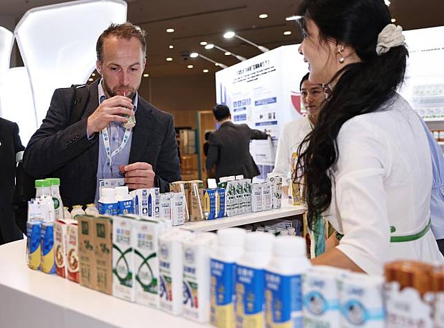 A guest visits the stand of China's Yili Group during the 2024 World Dairy Summit in Paris, France, on Oct. 15, 2024. (Xinhua/Gao Jing)