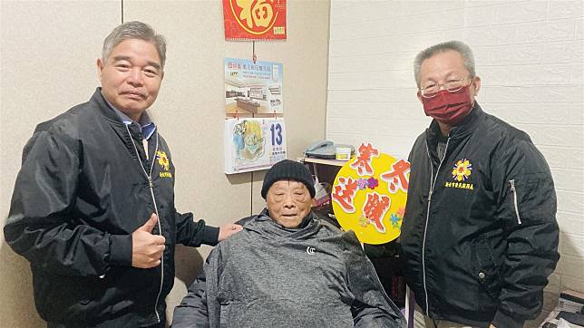 新北市榮民服務處處長林振生（左）致贈百歲榮民羅爺爺（中）保暖衣。（新北市榮民服務處提供）