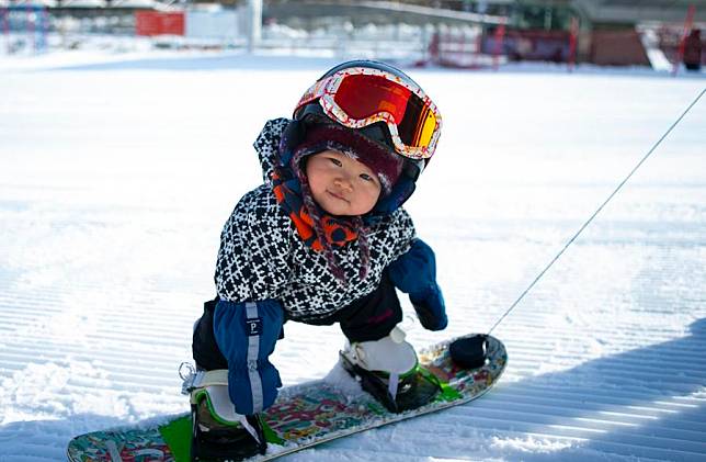 Eleven-month-old girl Wang Yuji enjoys snowboarding at Thaiwoo Ski Resort in Chongli District of Zhangjiakou City, north China's Hebei Province on Nov. 18, 2021. (Xinhua/Zhang Fan)