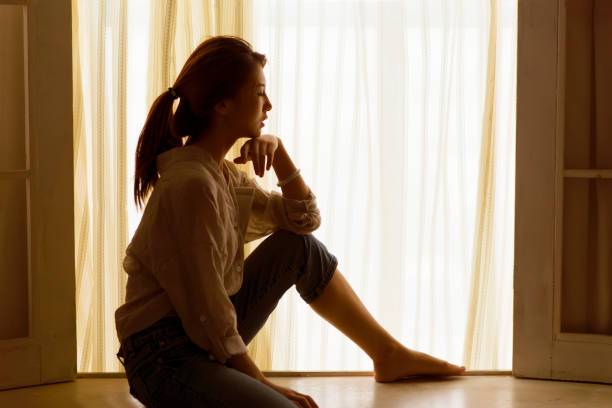 beautiful woman sitting on the windowsill.Sexy silhouette portrait.