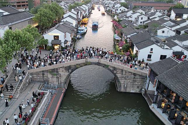 An aerial drone photo taken on May 2, 2024 shows tourists visiting a historical and cultural district along the Grand Canal in Wuxi, east China's Jiangsu Province. (Photo by Huan Yueliang/Xinhua)