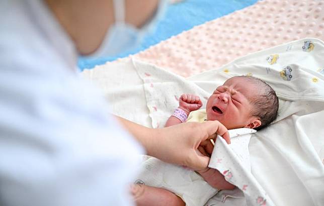 A nurse takes care of a newborn baby, whose Chinese zodiac sign is dragon, at a hospital in Ulanqab, north China's Inner Mongolia Autonomous Region, Feb. 10, 2024. (Xinhua/Lian Zhen)