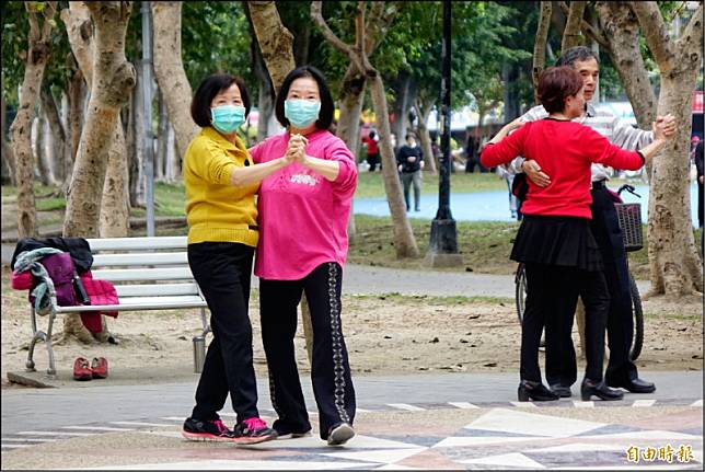 武漢肺炎疫情持續擴散，公園跳國標舞的社團，也有成員戴上口罩。(記者劉信德攝)