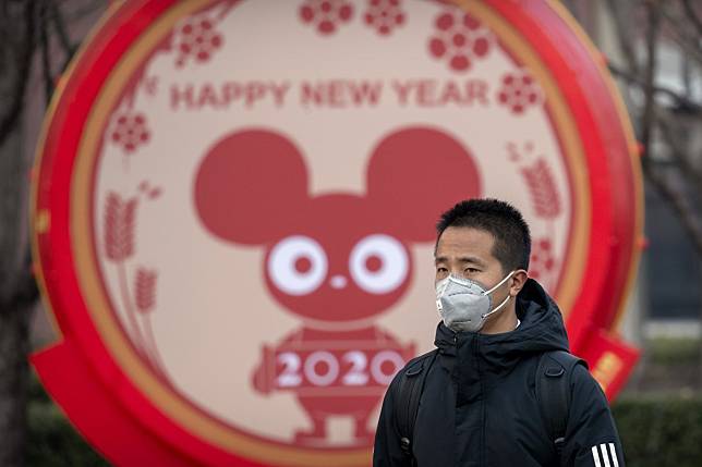 A man wears a face mask as he walks past a display for the Year of the Rat, in Beijing. The rat, for all it symbolises and represents, can give hope and determination for what would seem a challenging year. Photo: AP