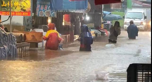 新北市金山老街和市場，淹水到大腿這麼高。(記者盧賢秀翻攝)