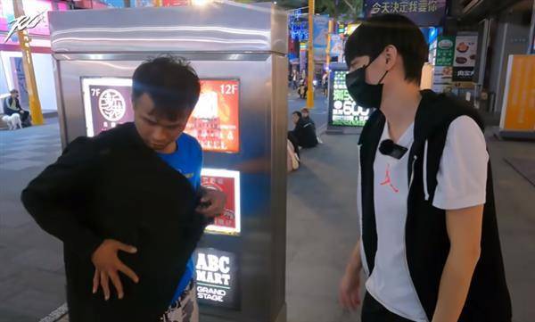 西門町年輕街友黃佳保（左）正在試穿YouTuber Ru儒哥（右）送他的外套。（圖片翻攝／YouTube_Ru儒哥）