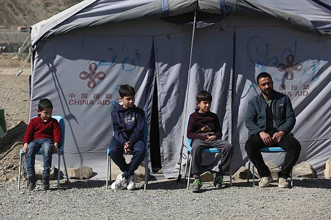 Refugees sit in front of a China-donated tent at the Torkham border crossing, Afghanistan, Feb. 13, 2025. (Photo by Saifurahman Safi/Xinhua)