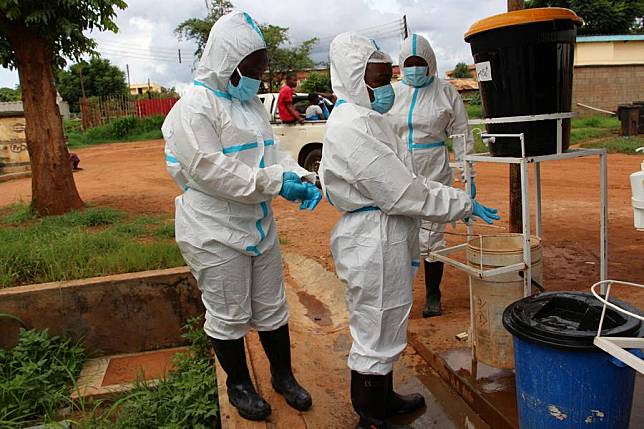 Environmental officers disinfect themselves after disinfecting a body at Bwaila hospital in Lilongwe, Malawi, Jan. 17, 2023. (Photo by Roy Nkosi/Xinhua)