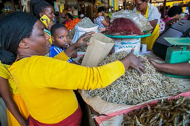 A vendor packs dried fish with a paper bag at Kimironko market in Kigali, Rwanda, July 14, 2022. (Photo by Cyril Ndegeya/Xinhua)