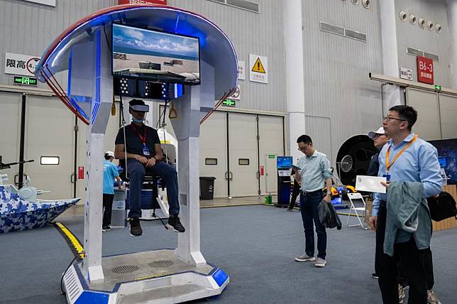 A visitor tries a VR parachute at an exhibition on aerospace in Wuhan, central China's Hubei Province, April 23, 2024. (Xinhua/Hu Jingwen)