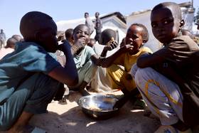 2025年11月22日，查德東部的臨時難民營，一群逃離蘇丹法舍的難民兒童正在用餐。路透社