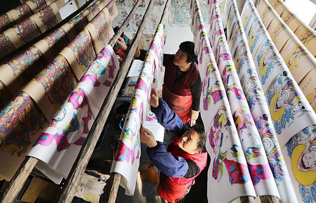 Folk artists hang newly-made woodblock new year paintings up to dry in Yangjiabu Village of Hanting District in Weifang, east China's Shandong Province, Jan. 10, 2017. (Xinhua/Zhang Chi)