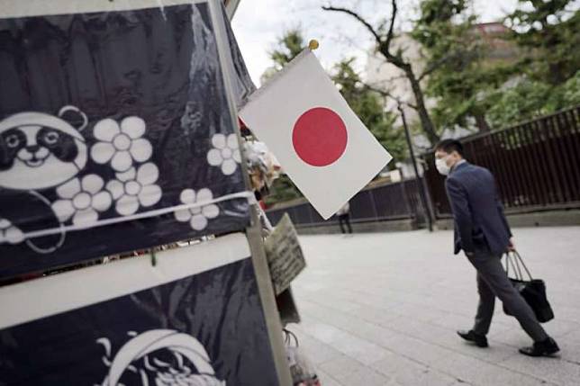 日本疫情升高，東京淺草區的往來行人也都戴著口罩。（美聯社）