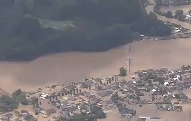 日本九州出現超大豪雨，熊本縣和鹿兒島縣都已傳出災情；球磨川水位暴漲沖垮房屋，還沖斷一座橋梁。   圖：翻攝自NHK影片