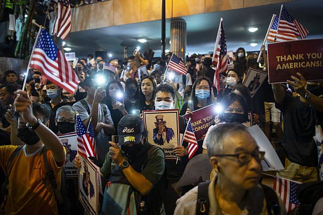 Demonstrators hold placards and American flag during a rally in support of the Hong Kong Human Rights and Democracy Act in Hong Kong. Photo: Bloomberg