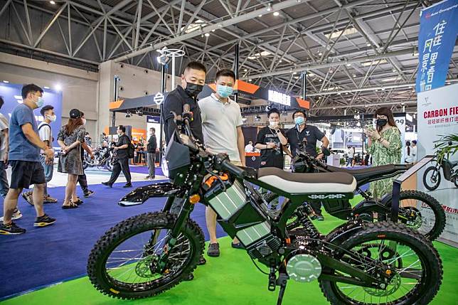 A staff member introduces an electric off-road motorcycle made of ultra-light carbon fiber materials during the 2022 Chongqing International Auto Exhibition in southwest China's Chongqing Municipality, June 25, 2022. (Xinhua/Huang Wei)