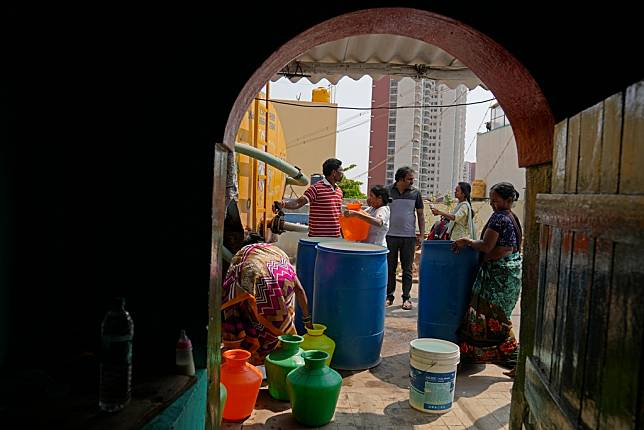 邦加羅爾外圍貧民區居民聽到載水車要來，拿出家裡各式水桶來買水備用。圖片來源 LINE TODAY：AP / 達志影像  
