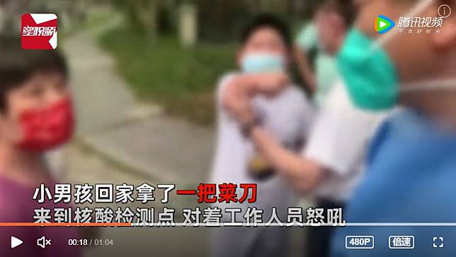 中國一名男孩(圖中)不滿被核酸檢測工作人員管教，持刀向工作人員怒吼。   圖：翻攝自騰訊
