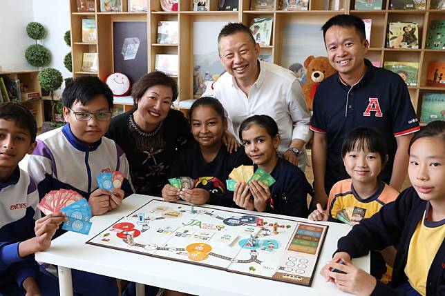 Dr William Lo, chairman of Junior Achievement Hong Kong (centre), alongside Principal Irene Lai Yuen-shan, and teacher To Kwok-kuen, with Primary Six pupils at Pat Heung Central Primary School, in Yuen Long. Photo: K.Y. Cheng