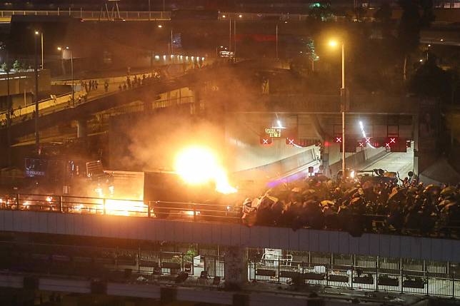 A police armoured vehicle is set on fire by protesters on the Cheong Wan Road flyover during clashes with riot police near Polytechnic University. Photo: Sam Tsang