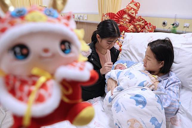 A newborn baby, whose Chinese zodiac sign is dragon, is seen with the mother and sister at a hospital in Wuxi, east China's Jiangsu Province, Feb. 10, 2024. According to the Chinese zodiac and tradition, the Year of Dragon symbolizes courage, auspiciousness and good luck. (Photo by Zhu Jipeng/Xinhua)