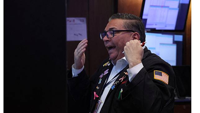 美股12月13日在聯準會宣布利率凍漲後大幅上揚，紐約證券交易所營業員振臂歡呼。路透社