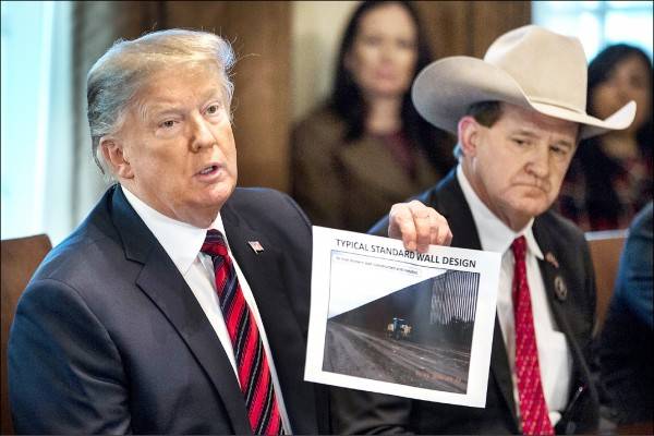 川普(左)十一日在白宮舉行邊境安全會議，期間出示邊境圍牆照片說明其必要性。(彭博)