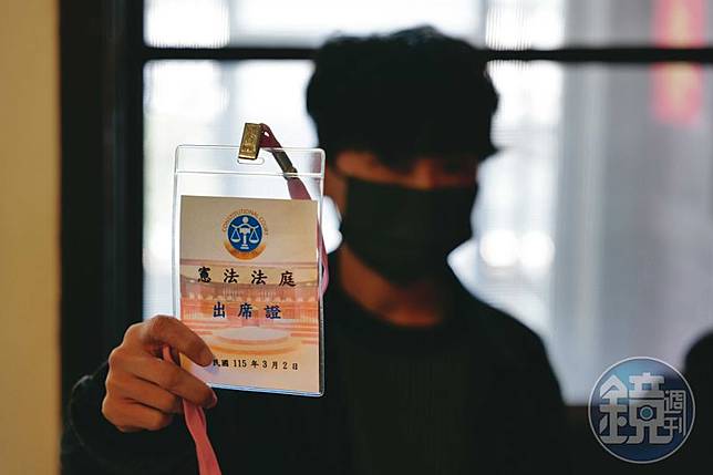 J拿著3月2日憲法法庭不公開說明會的出席證，她正在等待釋憲的結果。