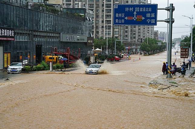 A vehicle moves on a waterlogged road in Shexian County, Huangshan City, east China's Anhui Province, June 23, 2024. (Xinhua/Du Yu)