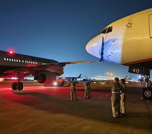 長榮航空空中巴士321客機(左，編號B-16227)16日晚間由長榮航勤拖行時，機翼意外撞破另一架長榮航空波音777客機(右)機鼻。(讀者提供)