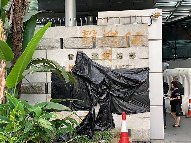 警方用黑色垃圾膠袋遮蓋牆身的塗鴉標語及遭受破壞的門牌(商台新聞 郭智晴攝)