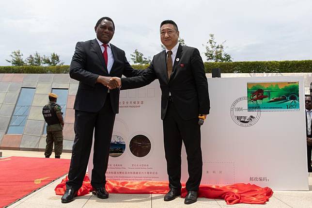 Zambian President Hakainde Hichilema (L) and Chinese Ambassador to Zambia Han Jing shake hands after unveiling the commemorative envelope for the 60th anniversary of the establishment of diplomatic relations between China and Zambia at the Tanzania-Zambia Railway (TAZARA) Memorial Park in Chongwe District, about 39 km east of Lusaka, the capital of Zambia, Oct. 29, 2024. (Xinhua/Peng Lijun)