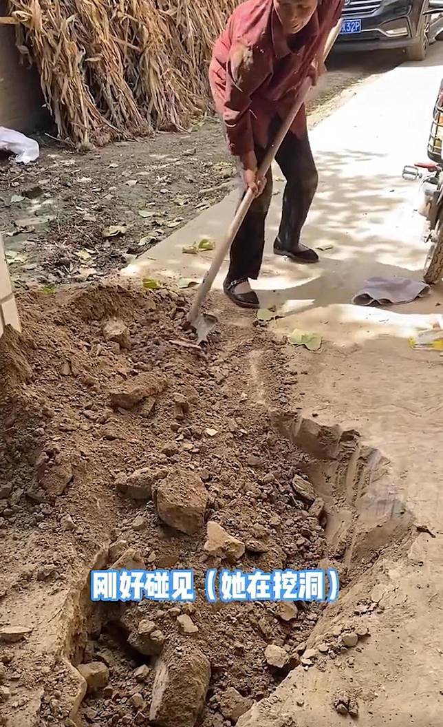 老婦人拿鐵鏟在家門前挖土。（翻攝微博）