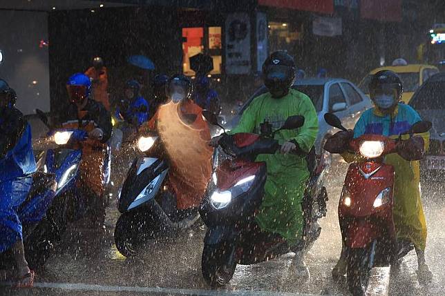 台北市信義區25日午後下起大雷雨，天空烏雲密布， 讓天色昏暗彷彿入夜一般，街頭機車騎士在雨中皆是 全副武裝，穿著雨衣冒雨通勤。 中央社記者趙世勳攝 111年8月25日