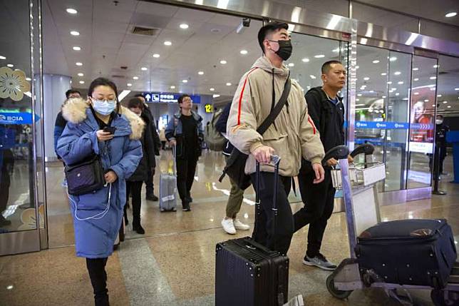 武漢肺炎疫情不斷升高，北京首都機場的旅客也紛紛戴起口罩。（美聯社）