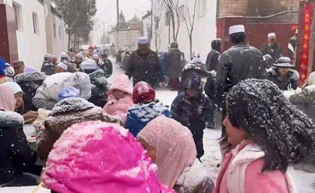 中國寧夏一對新人舉辦婚宴時巧遇大雪，賓客直接露天吃喜酒。（翻攝微博）