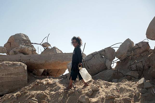 A Palestinian child returns home after filling bottles with water from a vehicle distributing free water in the southern Gaza Strip city of Khan Younis, Oct. 20, 2024. (Photo by Rizek Abdeljawad/Xinhua)