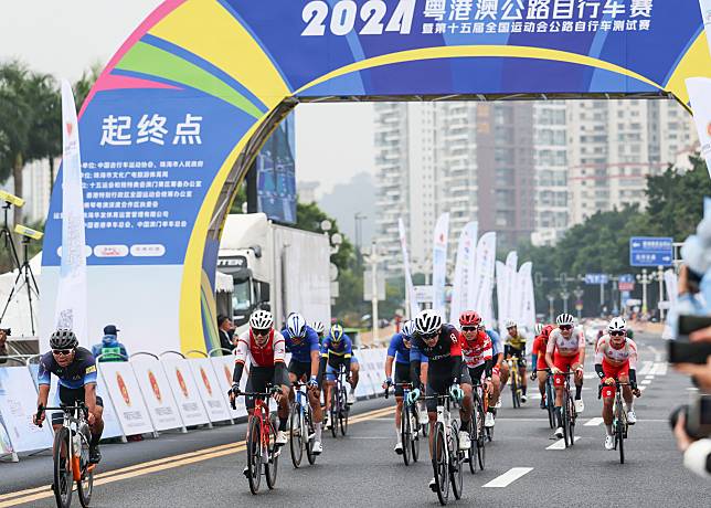 Cyclists cross the finish line during the 2024 Guangdong-Hong Kong-Macao Road Cycling Race and the test event for China's 15th National Games in Zhuhai, south China's Guangdong Province, Nov. 24, 2024. (Xinhua/Liu Dawei)